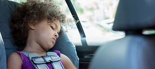 Girl sleeping in car seat.