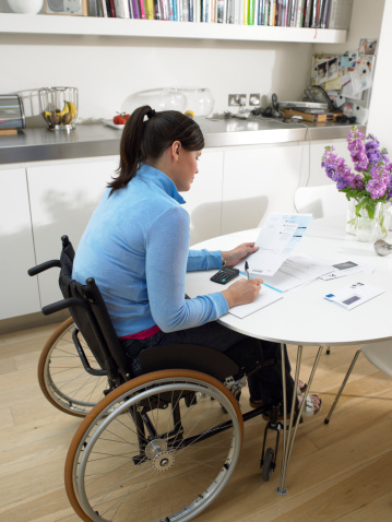 Woman in wheelchair working at home