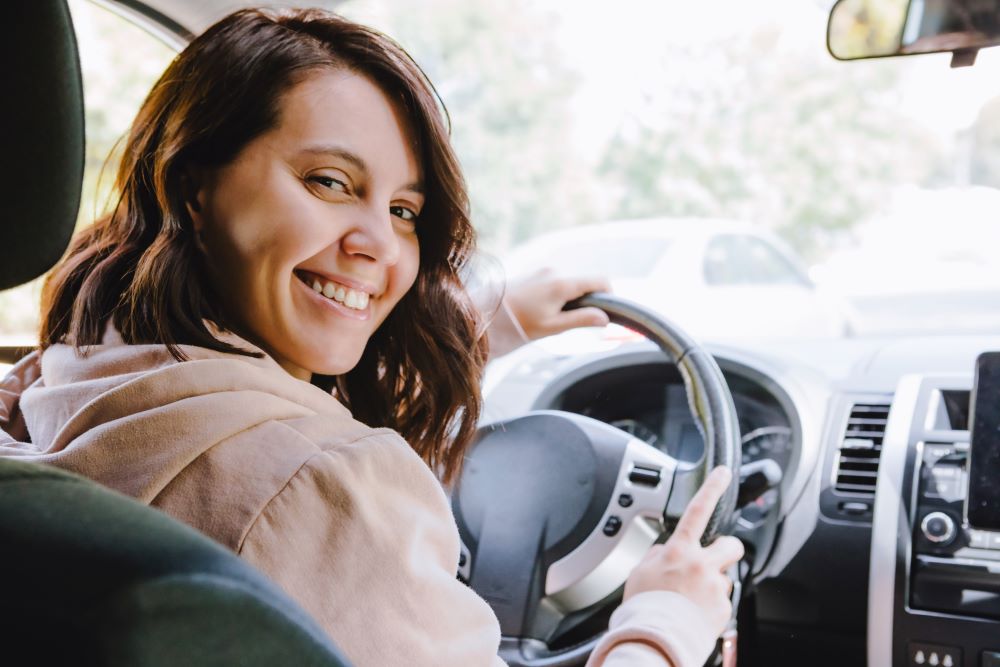 Woman driver behind steering wheel.